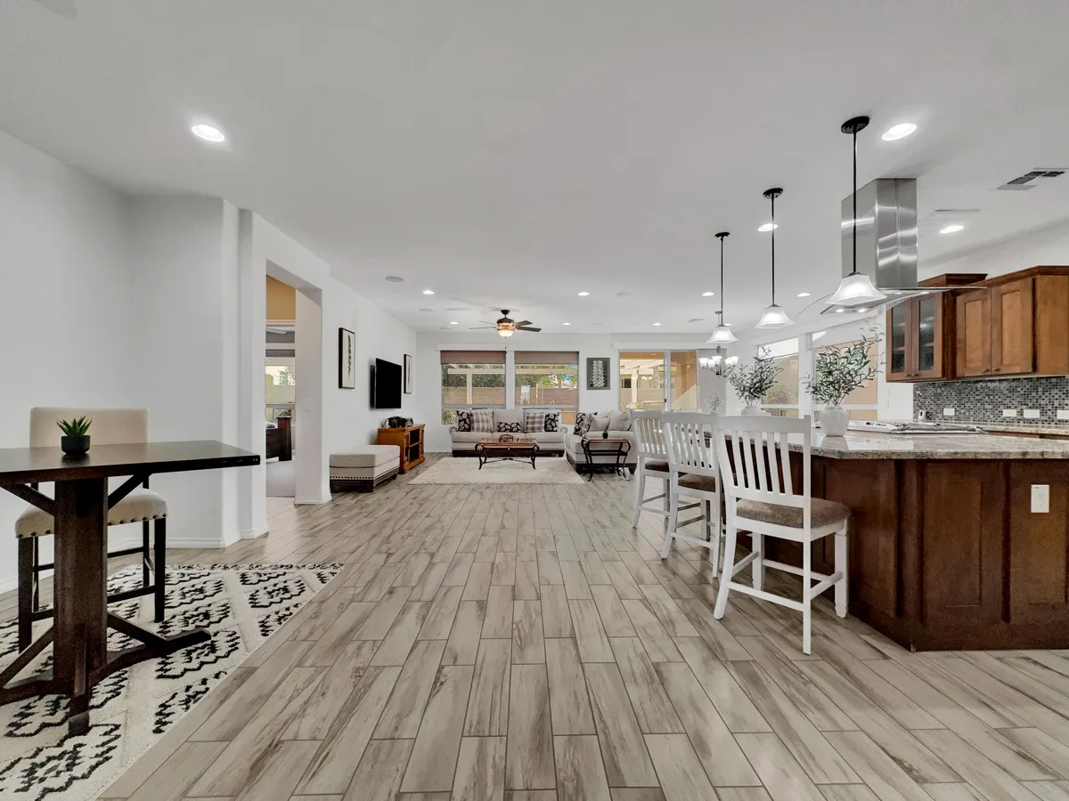 This image features a spacious and modern kitchen island, a dining table, and a comfortable seating area. The overall layout encourages cooking, entertaining, and communal gatherings, with the kitchen island serving as a central hub for activity.