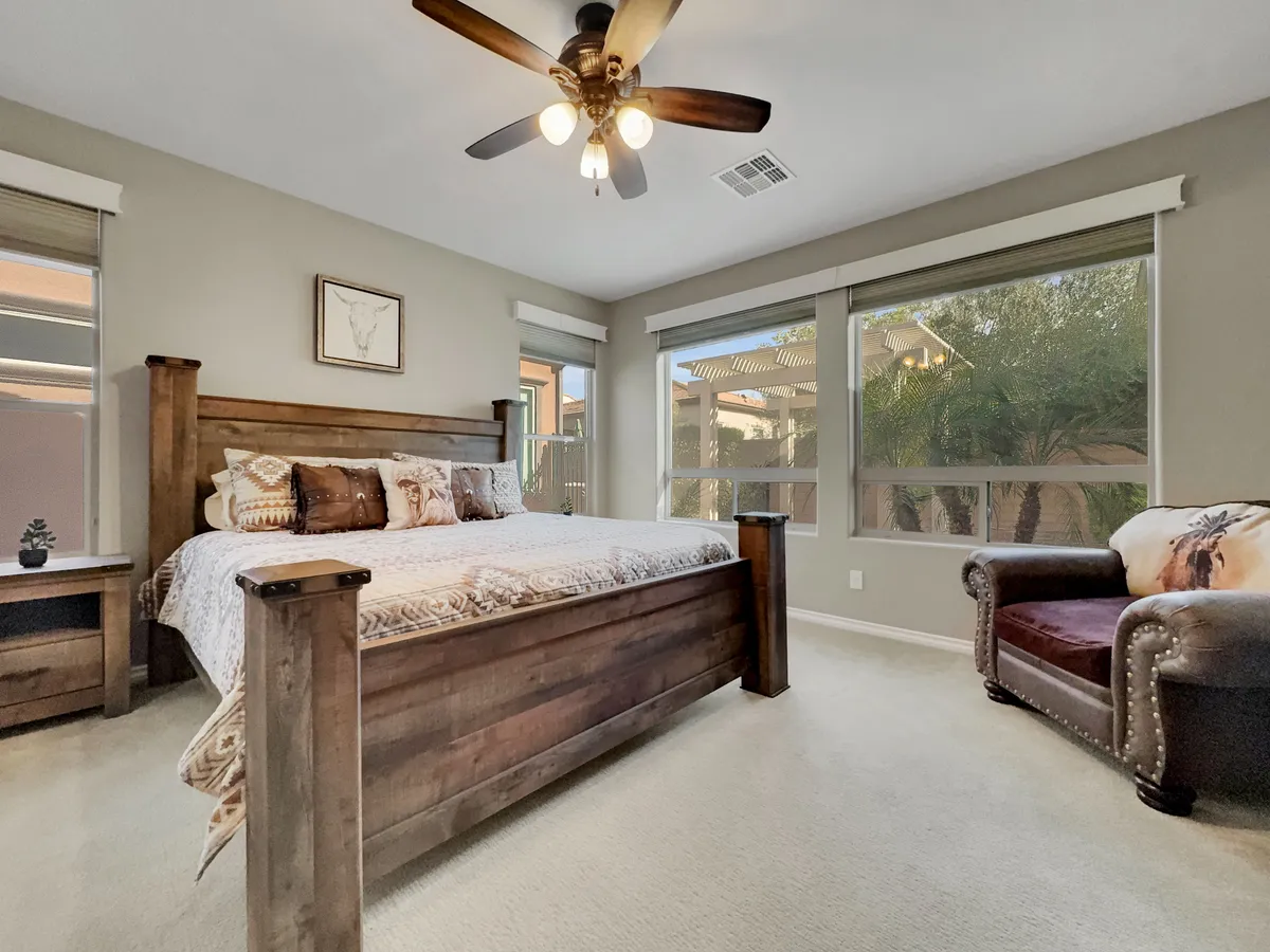 A bright and inviting guest bedroom that features a plush queen bed, a cozy armchair near the window, and soft natural light. The room is styled for comfort and privacy, with simple yet elegant decor that promotes deep relaxation—ideal for guests seeking a peaceful retreat.